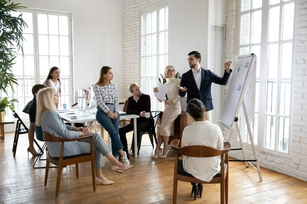 Un homme d'affaires confiant présente un projet d'entreprise sur un tableau à feuilles mobiles — Photo