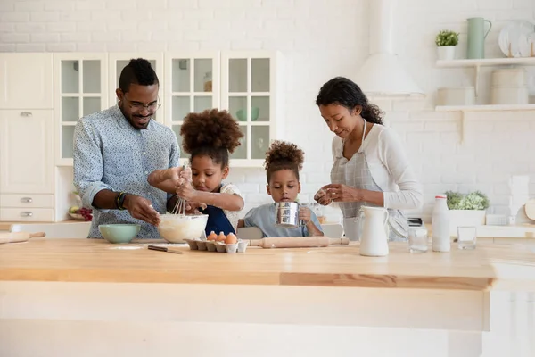 Šťastný africký Američan plná rodina těší přípravy ranní víkendové jídlo. — Stock fotografie