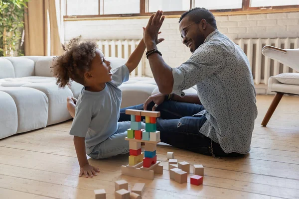 Pequeno menino afro-americano dando cinco ao papai sorridente. — Fotografia de Stock