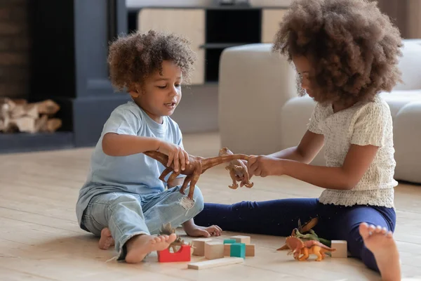 Amistosos dos pequeños niños afroamericanos jugando en el suelo. — Foto de Stock