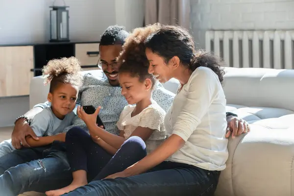 Glad bindning tillgiven afrikansk amerikansk familj med hjälp av smartphone. — Stockfoto