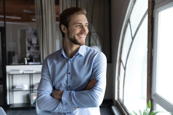 Joyeux jeune beau leader regardant au loin dans la fenêtre. — Photo