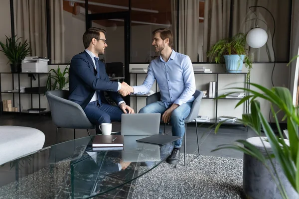 Felice due partner maschi che si stringono la mano, facendo un accordo in ufficio. — Foto Stock