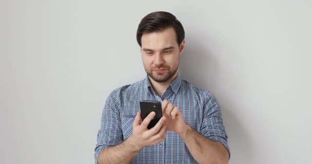 Emotionaler junger Mann mit lustigen mobilen Anwendungen. — Stockvideo