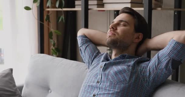 Fiatal álmodozó boldog férfi pihentető kényelmes kanapén. — Stock videók