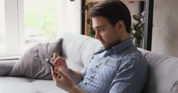 Kecanduan teknologi pria muda tampan menggunakan aplikasi smartphone. — Stok Video