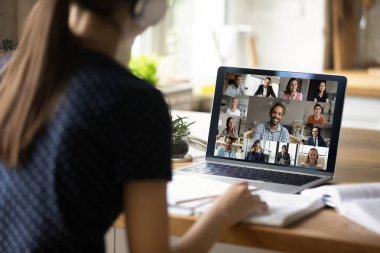 Kadın öğrencinin arka planda grup olarak webcam dersi var