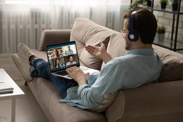 Muž ve sluchátkách mají tým on-line setkání na notebooku — Stock fotografie