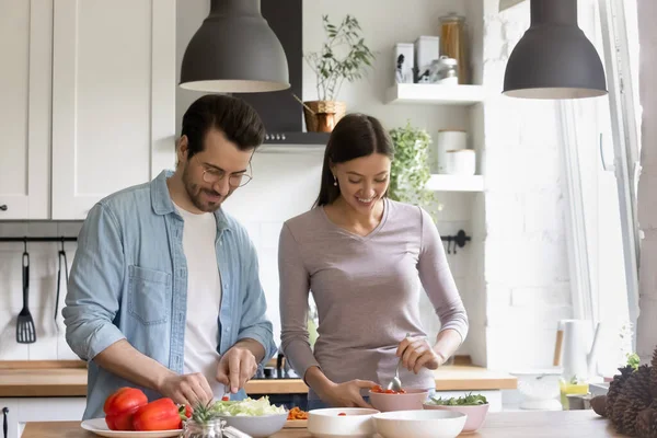 Glückliches Familienpaar hackt frisches Gemüse für Salat. — Stockfoto