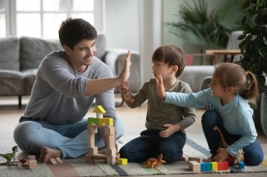 Mutlu baba ve küçük çocuklar beşlik çakıyor