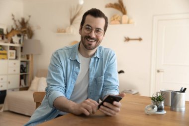 Elinde akıllı telefon olan mutlu bir gencin portresi..