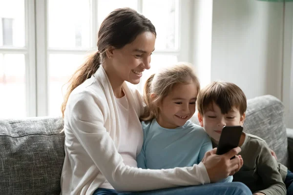 Madre sorridente e bambino usano il cellulare insieme — Foto Stock