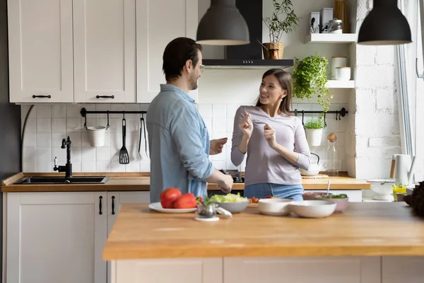 Verspieltes junges Ehepaar tanzt zu energiegeladener Musik in Küche. — Stockfoto