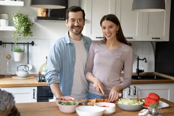 Portrait de heureux jeune couple marié cuisiner ensemble dans la cuisine. — Photo