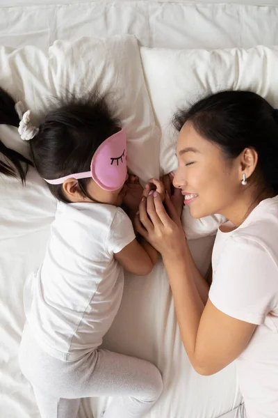 Vista dall'alto sorridente asiatica madre e bambina dormire — Foto Stock