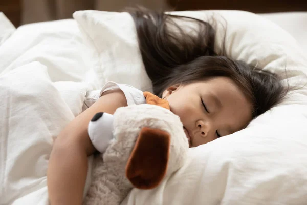 Cerca hasta lindo sereno asiática niña abrazando juguete, durmiendo — Foto de Stock