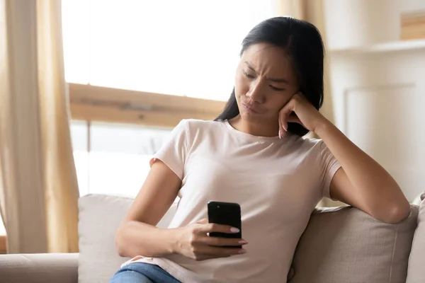Boldogtalan elégedetlen ázsiai nő néz smartphone képernyő — Stock Fotó