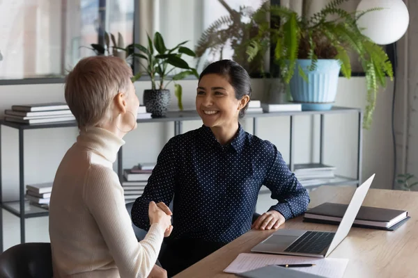 Smiling diverse businesswomen handshake greeting at meeting — Stock Photo, Image