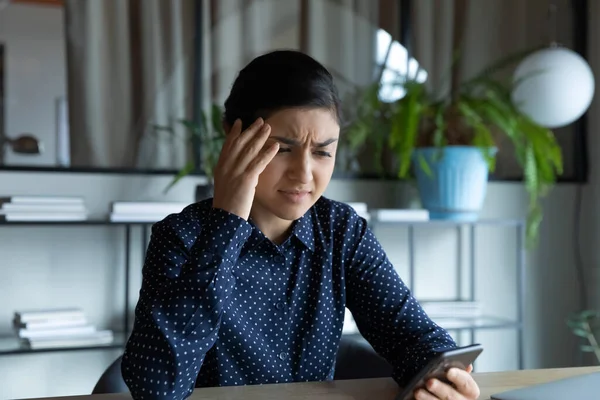 Olycklig indian kvinna bedrövad av meddelande på mobiltelefon — Stockfoto