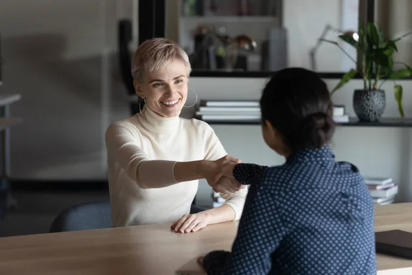 Smiling diverse female colleagues handshake at business meeting — Stock Photo, Image