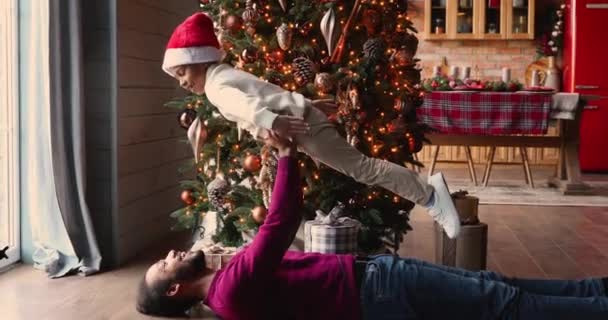 African father lifts up son enjoy playtime on Christmas Eve