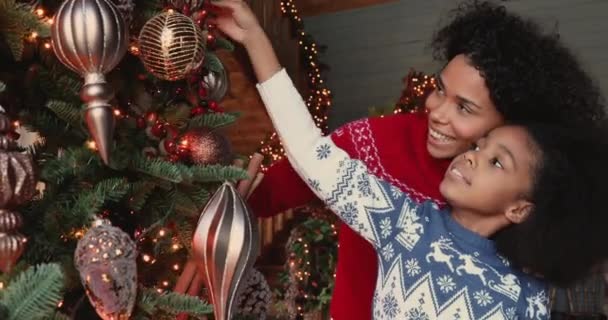 Mamá africana y su hija decorando el árbol de Navidad en casa — Vídeos de Stock