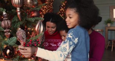 Mutlu Afrikalı aile ve Noel ağacı süsleyen küçük çocuklar.