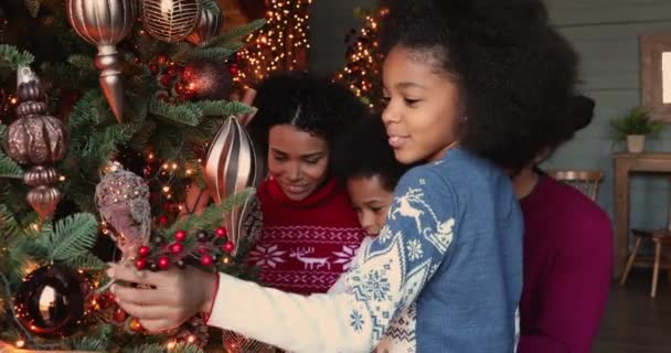 Feliz familia africana con niños pequeños decorando el árbol de Navidad — Vídeos de Stock