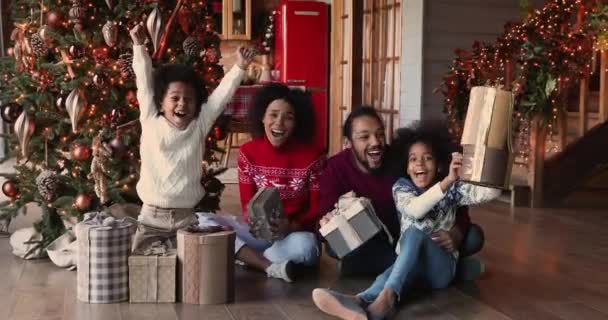 新年を祝うクリスマスツリーの近くに幸せなアフリカの家族が座る — ストック動画