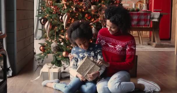 Africana hija y mamá sentarse en el suelo cerca de árbol de Navidad — Vídeos de Stock