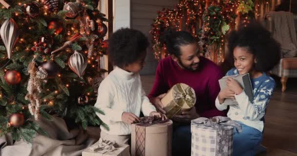 Familia africana celebrando la Navidad hablando cajas de espera con regalos — Vídeos de Stock