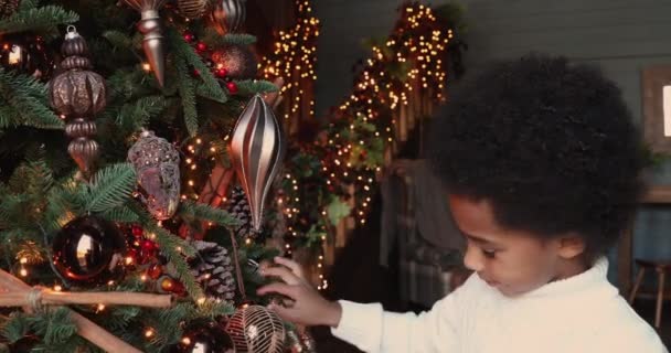 かわいいアフリカ民族の少年クリスマスツリーを飾る — ストック動画