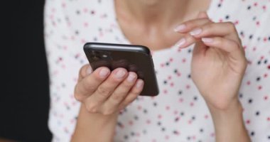 Yakın çekim görüntüsü olan kadın akıllı telefon kullanarak internette vakit geçiriyor.