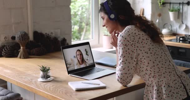Woman wear headphones talking with girlfriend by videocall — Stock Video