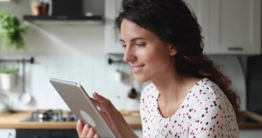 Elinde tablet olan kadın uzaktan yemek siparişi veriyor.