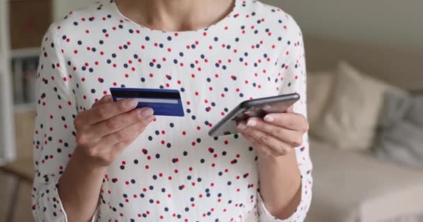 Close-up bekijken vrouw houdt mobiele telefoon online betalen met een creditcard — Stockvideo