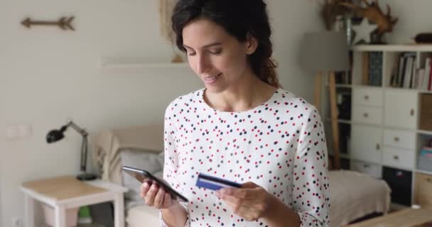 Frau mit Smartphone und Kreditkarte macht elektronische Zahlung — Stockvideo