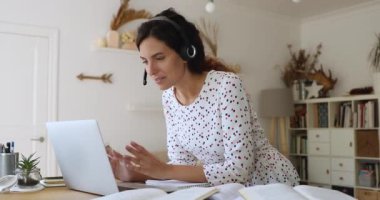Webinar sırasında video uygulaması ile konuşan bir kadın kulaklık takıyor.