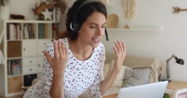 Videoyla iletişim kuran bir kadın bilgisayara bakarak konuşuyor.