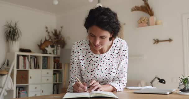 Młoda kobieta trzyma ołówek pisząc ważne notatki w planerze osobistym — Wideo stockowe