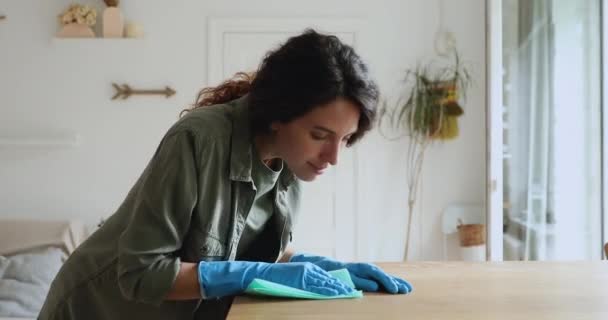 Женщина носит защитные перчатки очищает стол улыбки глядя в камеру — стоковое видео