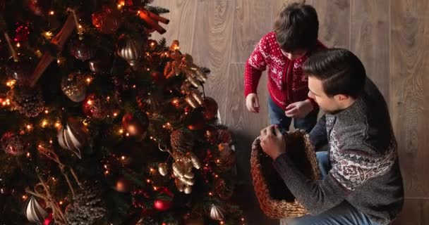 Yukarıda mutlu bir baba ve küçük bir oğul Noel ağacı süslüyorlar — Stok video