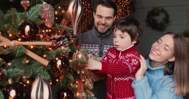 Happy young couple his preschool son decorating Christmas tree — Stock Video