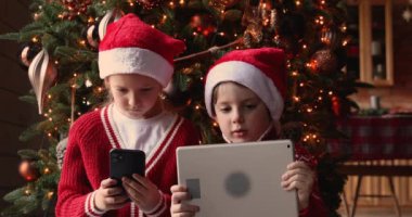 Çocuklar Noel ağacının yanında oturan kostüm giyerler.