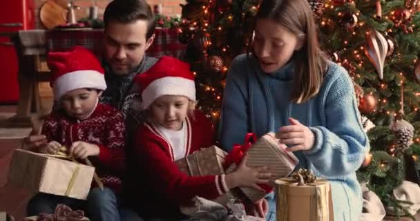 Parents et enfants réunis près de l'arbre de Noël profiter de cadeaux ouverture — Video