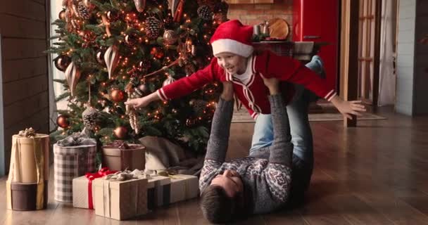 Father lifts daughter flying in air enjoy playtime on Christmas
