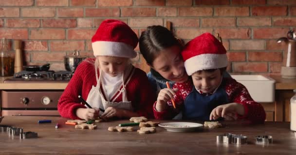 Sevgi dolu anne ve çocuklar masada oturup xmas kurabiyeleri hazırlıyorlar. — Stok video