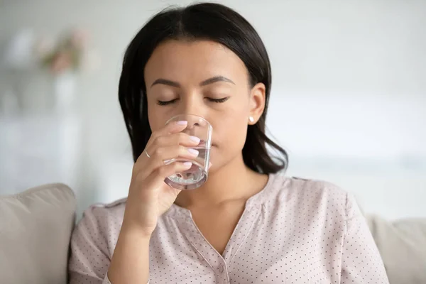 Жаждущая двуличная женщина пьет воду из стекла — стоковое фото