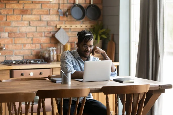 Young African American man use laptop at home kitchen — Stock Photo, Image