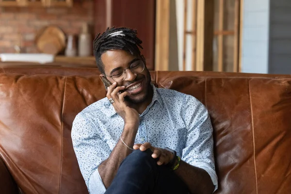 Leende afroamerikansk man prata på smartphone hemma — Stockfoto